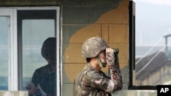 Seorang tentara Korea Selatan meneropong di pos pemeriksaan militer di Imjingak Pavilion dekat perbatasan dengan Korea Utara, Korea Selatan, Minggu, 13 Juli 2014. Korea Utara meluncurkan dua rudal balistik hair Minggu, menurut Korea Selatan.