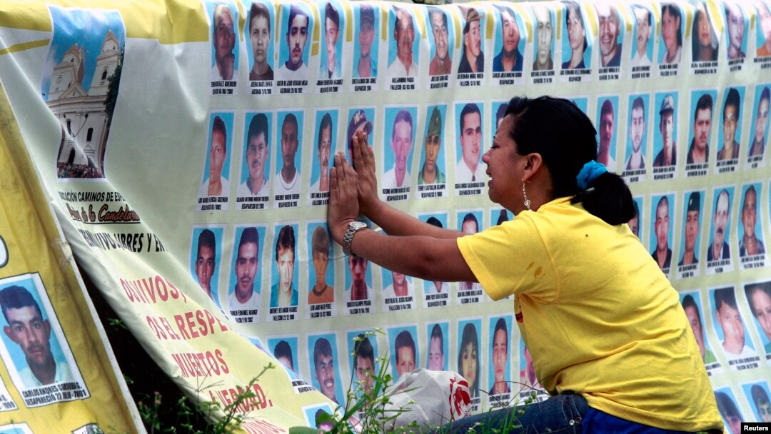 Seorang perempuan menangis di depan barisan foto orang hilang di kota Medellin, Kolombia. (Foto: Dok)