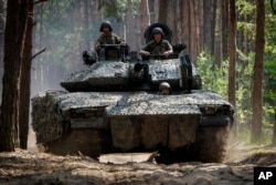 Tentara Ukraina dari brigade ke-57 mengendarai Kendaraan Tempur Swedia 90 di dekat garis depan di wilayah Kharkiv, Ukraina, Selasa, 18 Juni 2024. (Foto: AP)