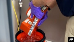 In this image provided by the National Transportation Safety Board, NTSB investigators examine the flight data recorder in Washington, Jan. 30, 2025, recovered from the jet that crashed with a helicopter near Ronald Reagan Washington National Airport.