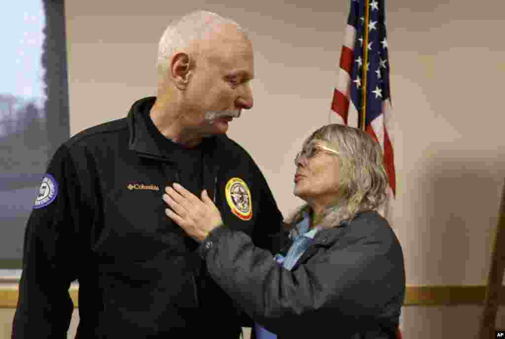 Robin Youngblood smiles after embracing Snohomish County helicopter crew chief Randy Fay, who helped rescue her after a deadly mudslide in Washington, March 26, 2014.