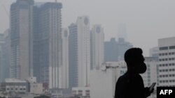 Seorang pria mengenakan masker sementara kabut asap tampak menyelimuti Kuala Lumpur, Malaysia, 10 September 2019. (Foto: AFP)