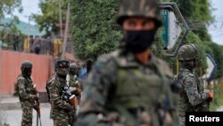 FILE - India's Central Reserve Police Force personnel stand guard alongside a road in Srinagar, May 6, 2020. 