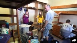 FILE - Paul and Robin Kramer from Chicago help their daughter Ariana move into her dormitory room on the campus of the University of Iowa in Iowa City, Aug. 16, 2010.