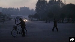 FILE - North Koreans make their way across an intersection at the end of a work day in Pyongyang, North Korea.