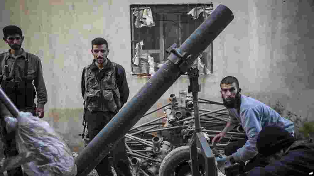 Free Syrian Army fighters reload a mortar tube during clashes with government forces in Kafr Nboudah village, northern Syria.