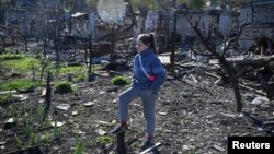 9-річна жителька Куп'янська стоїть на руїнах, що залишились від її домівки внаслідок повномасштабного російського вторгнення в Україну, 17 жовтня 2022. REUTERS/Viacheslav Ratynskyi
