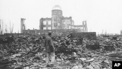 Seorang koresponden perang Sekutu berdiri di reruntuhan Hiroshima, Jepang, hanya beberapa minggu setelah kota itu diratakan oleh bom atom pada tahun 1945. (Foto: AP)