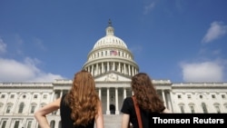 Women gaze at the dome of the US Capitol, days after the removal of security fencing which was placed around the complex after the Jan. 6 attack, in Washington, July 12, 2021. 