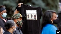 A supporter holds up a shirt to call attention to the death of Elijah McClain in August 2019 in Aurora, Colo., during a news conference at the State Capitol on June 19, 2020.