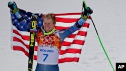 Men's giant slalom gold medalist Ted Ligety of the United States poses for photographers on the podium at the Sochi 2014 Winter Olympics, in Krasnaya Polyana, Russia, Feb. 19, 2014.