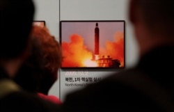 Visitors watch a photo showing North Korea's missile launch at the Unification Observation Post in Paju, South Korea, near the border with North Korea, Friday, April 19, 2019.