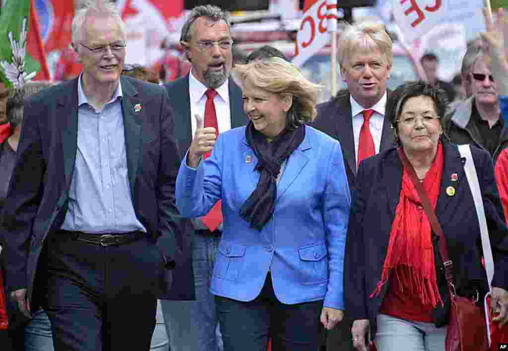 Governor and top candidate of the German social democrats (SPD) for state elections in North-Rhine Westphalia, Hannelore Kraft, center, shows thumb up during a union march in Dortmund, Germany, May 1, 2012. (AP Photo)