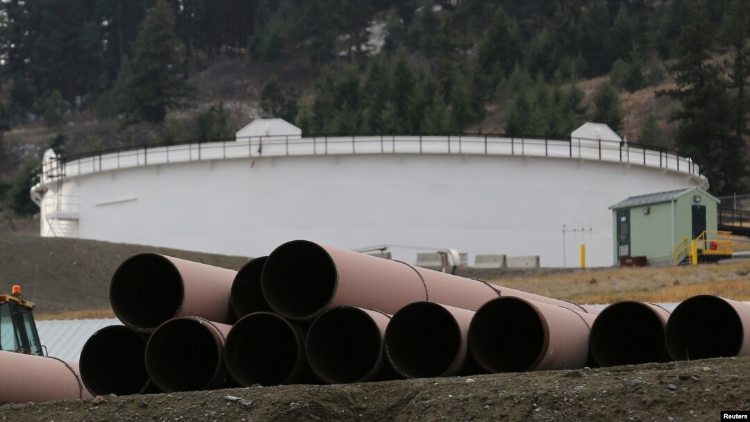 FILE - Replacement pipe is stored near crude oil storage tanks at Kinder Morgan's Trans Mountain pipeline terminal in Kamloops, British Columbia, Canada, Nov. 15, 2016. 