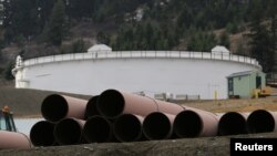 FILE - Replacement pipe is stored near crude oil storage tanks at Kinder Morgan's Trans Mountain pipeline terminal in Kamloops, British Columbia, Canada, Nov. 15, 2016. 
