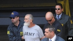 Norberto Gonzalez Claudio, 65, is being escorted by FBI agents after his court appearance in San Juan, Puerto Rico, May 10, 2011
