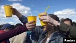 FILE - Unidentified students hold drinks at an outdoor gathering. Two deaths from alleged hazing on college campuses in the U.S. so far this year have refueled criticism of some sororities and fraternities.