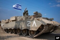 Seorang tentara Israel mengacungkan tanda V saat menuju perbatasan Jalur Gaza di Israel selatan, Sabtu, 14 Oktober 2023. (Foto: AP/Ariel Schalit)