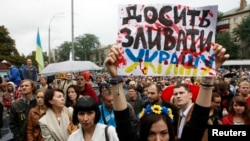 Militan ak manm fanmi sòlda ikrenyen ki di rebèl separats pwo-Larisi ansèkle sòlda yo nan pati lès Ikrèn, ap manifeste devan Ministè Defans la nan Kyèv. (Foto: 28 out 2014). 