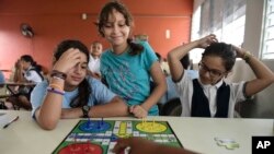 Girls play a board game at the Ramon Marin Sola Elementary School, which opened its doors as a daytime community center after the passing of Hurricane Maria in Guaynabo, Puerto Rico, Oct. 13, 2017. 