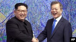 Pemimpin Korut Kim Jong Un (kiri) dan Presiden Korsel Moon Jae-in dalam pertemuan di Panmunjom, 27 April 2018 lalu. 