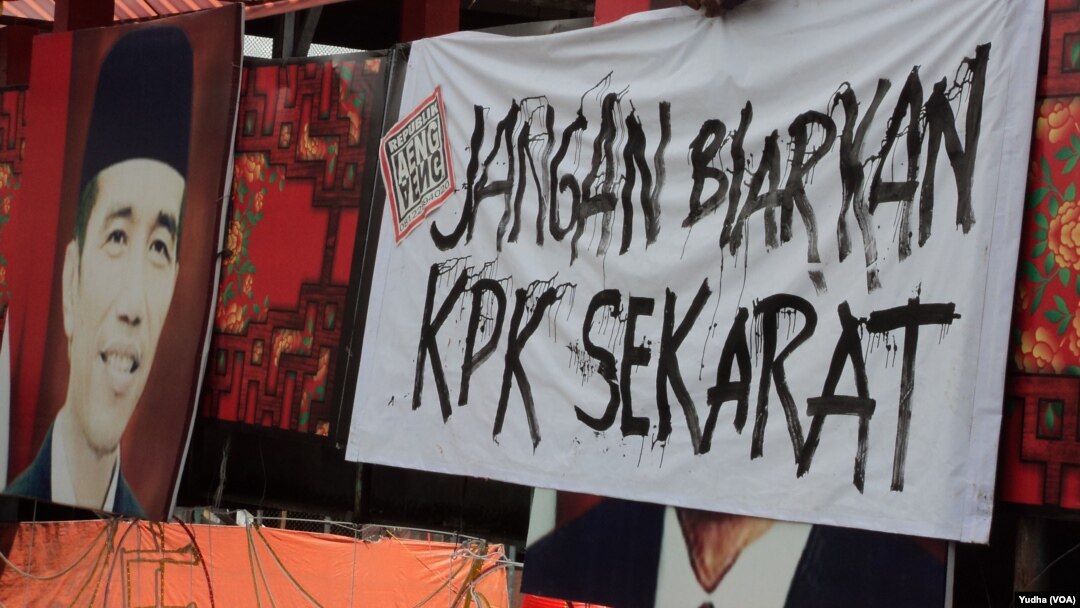 Seorang warga tengah memasang spanduk bertuliskan pesan agar Presiden "Jangan Biarkan KPK Sekarat" di Solo, 18 Februari 2015 (Foto: VOA/Yudha).