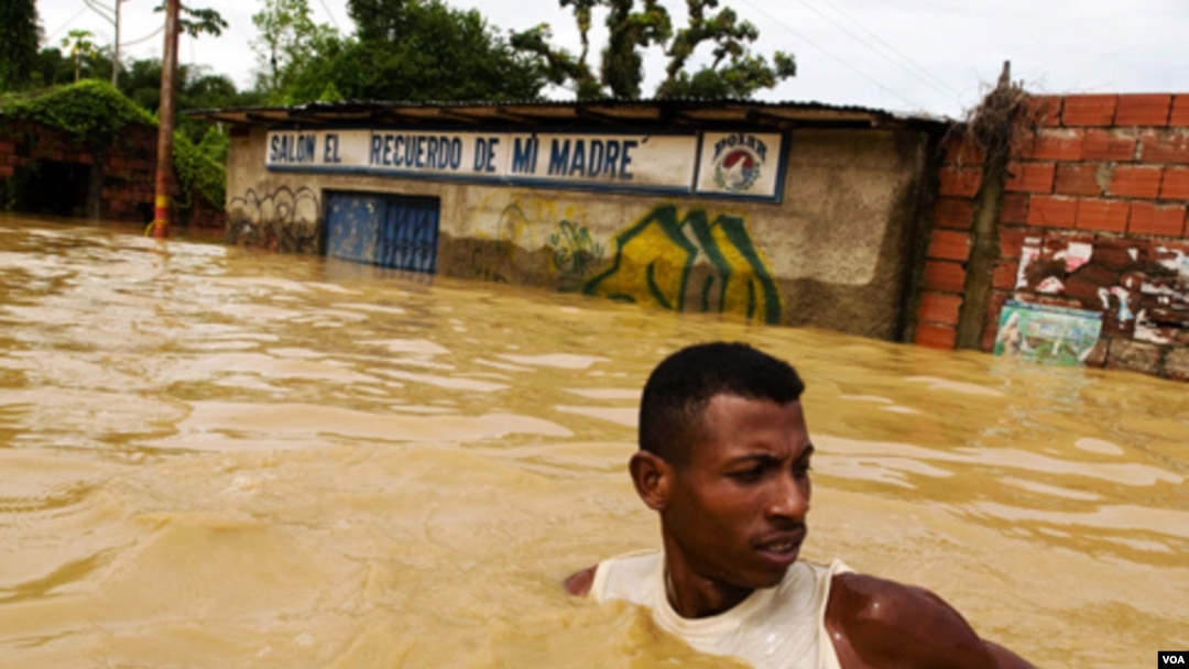 Un hombre trata de cruzar una calle inundada en el poblado de Barlovento, en el venezolano estado de Miranda.