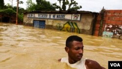 Un hombre trata de cruzar una calle inundada en el poblado de Barlovento, en el venezolano estado de Miranda.