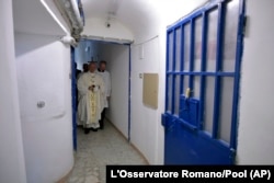 FILE - Pope Francis walks inside the Paliano detention center, south of Rome, April 13, 2017.