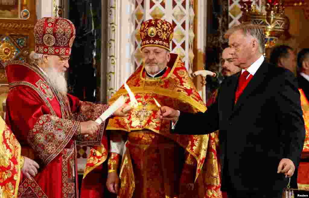 Patriarch Kirill (left), the head of the Russian Orthodox Church, and Vladimir Yakunin (right), chairman of the board of trustees of St. Andrew the First-Called foundation, attend the Orthodox Easter service at the Christ the Saviour Cathedral in Moscow, 
