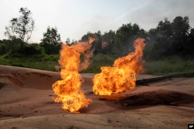A burning flare is visible at an oil extraction area located in Moanda, Democratic Republic of the Congo, Saturday, Dec. 23, 2023. (AP Photo/Mosa'ab Elshamy)