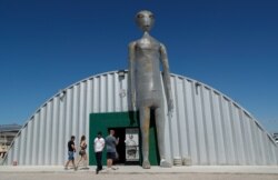 People enter and exit the Alien Research Center in Hiko, Nev. No one knows what to expect, but lots of people are preparing for "Storm Area 51" on Sept. 18, 2019, in the Nevada desert.