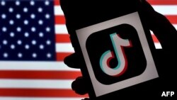 미국 국기를 배경으로 소셜미디어 앱 '틱톡'을 사용하고 있다.