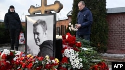 A man lays flowers at the grave of Russian opposition leader Alexey Navalny at the Borisovo cemetery in Moscow on Feb. 16, 2025, marking the first anniversary of his death in an Arctic colony under murky circumstances.