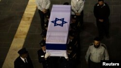 Members of the Knesset guard carry the flag-draped coffin of former Israeli prime minister Ariel Sharon outside the Knesset, Israel's parliament, in Jerusalem Jan. 12, 2014. 