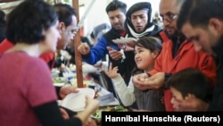 Les migrants reçoivent de la nourriture à un marché de Noël dans un abri de réfugiés géré par l'organisation caritative allemande Arbeiter Samariter Bund ASB à Berlin , Allemagne , le 12 Décembre , 2015. REUTERS / Hannibal Hanschke