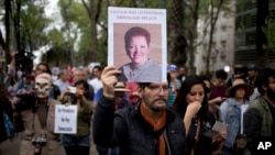 A man holds up a photo of Mexican journalist Miroslava Breach, gunned down in the northern state of Chihuahua on March 23, 2017, during a march in Mexico City, March 25, 2017. Breach was the third journalist to be killed this month in Mexico.