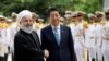 Japanese Prime Minister Shinzo Abe, center, shakes hands for the cameras with Iranian President Hassan Rouhani, during the official arrival ceremony, at the Saadabad Palace in Tehran, Iran, June 12, 2019. 