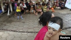 Warga antri untuk mendapatkan pengobatan gratis untuk anak-anak mereka dari rumah sakit Kantha Bopha di Phnom Penh, Kamboja (4/7). Penyakit misterius telah menyebabkan meninggalnya lebih dari 60 anak di Kamboja. 