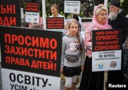 FILE - Anti-vaccination activists protest the decision of the Health Ministry and Education Ministry to not allow children without vaccination to go to school, in Kyiv, Ukraine, Aug. 22, 2019.
