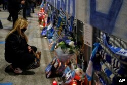 A woman pays her respects to soccer legend Diego Maradona outside the San Paolo Stadium, in Naples, Italy, Nov. 25, 2020.