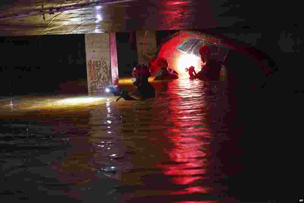 Civil Guards check cars for bodies in an flooded indoor car park after floods in Paiporta, near Valencia, Spain.