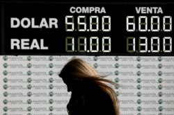 A woman walks past a currency exchange board in Buenos Aires, Argentina, Aug. 12, 2019.