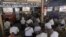 FILE - Customers at a coffee shop in Yangon watch a live television broadcast of new Myanmar President Htin Kyaw delivering his first address at the parliament in Naypyidaw during his swearing in ceremony, March 30, 2016. 