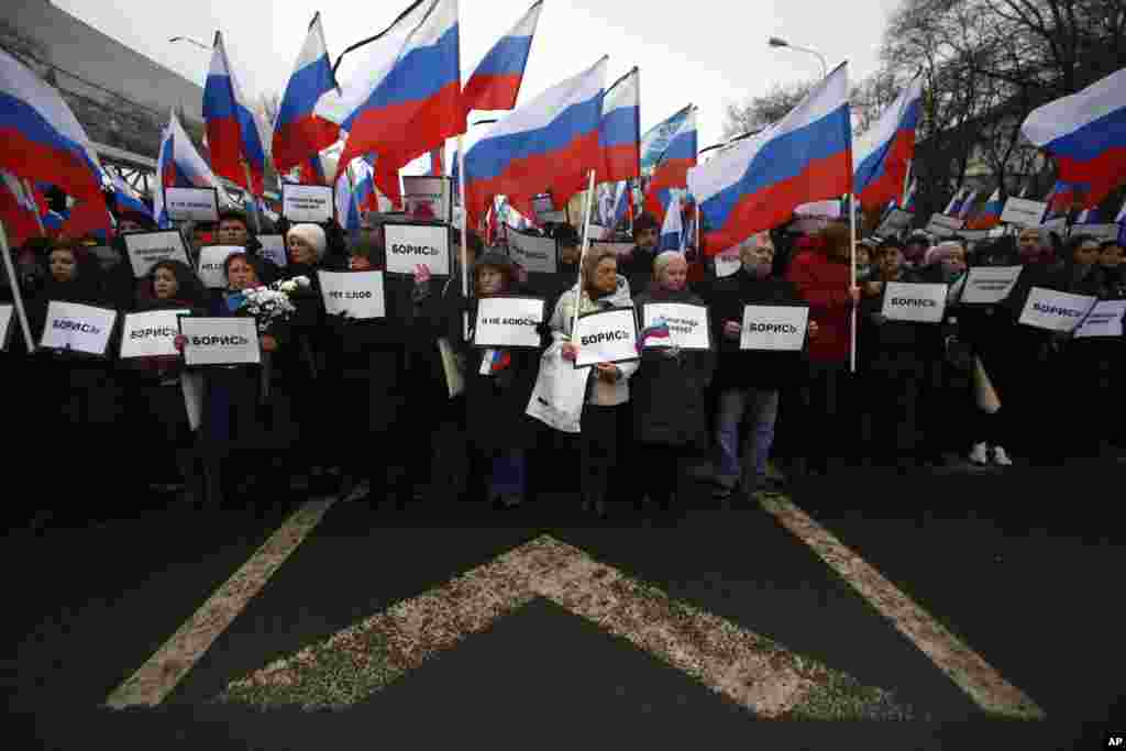 People carry Russian national flags as they march with posters reading "I have no fear, fight!" near the place opposition leader Boris Nemtsov was gunned down on Friday, near the Kremlin, in Moscow, Russia, March 1, 2015. 