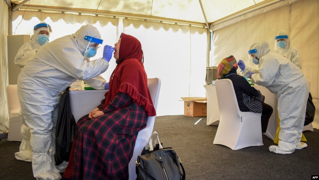 Para petugas kesehatan sedang melakukan tes usap (swab test) Covid-19 terhadap 28 orang yang tinggal di dalam kompleks Sekolah Calon Perwira Angkatan Darat (Secapa AD), di Bandung, Sabtu, 11 Juli 2020. (Foto: AFP)