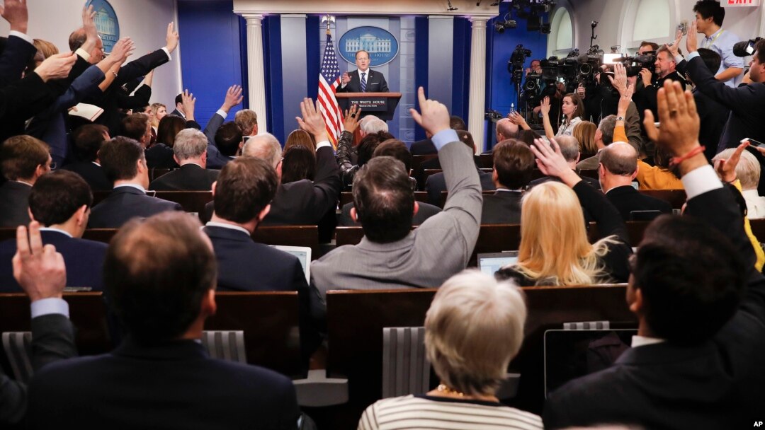 FILE - Reporters raise their hands as White House press secretary Sean Spicer takes questions during the daily briefing in the Brady Press Briefing Room of the White House in Washington, Feb. 22, 2017.