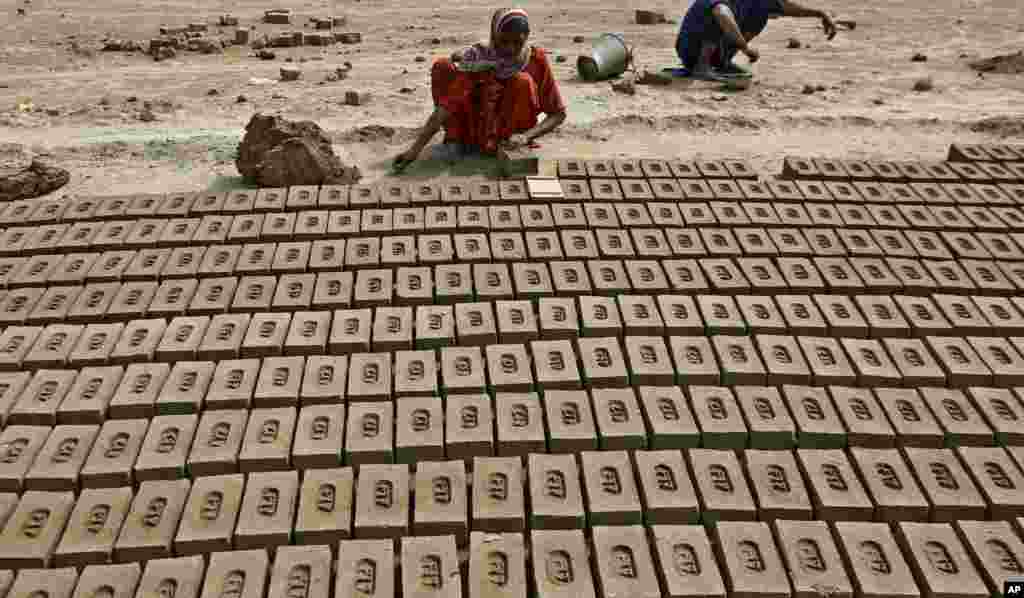 A woman organizes bricks at a kiln on the outskirts of Lahore, Pakistan.