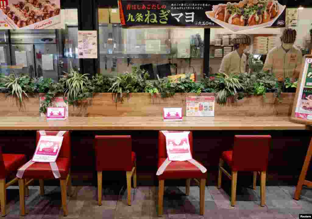 Social distancing signs are place on a table and chairs at a restaurant in Japan&#39;s supermarket group Aeon&#39;s shopping mall as the mall reopens amid the coronavirus disease (COVID-19) outbreak in Chiba, Japan May 28, 2020. REUTERS/Kim Kyung-Hoon