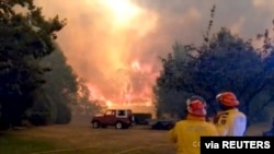 FILE - Firefighters work at the scene of a bushfire in Bilpin, New South Wales, Australia, in this still image from a social media video, Dec. 15, 2019. 